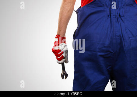 handyman with wrench in hand on gray background with copy space Stock Photo