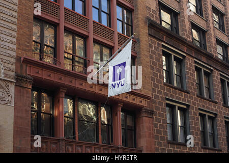 New York, NY, USA - February 6, 2017: A New York University banner hangs from a flagpole outside college buildings on Waverly Place Stock Photo