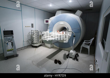 Patient being scanned and diagnosed on a MRI (magnetic resonance imaging) scanner in a hospital. Modern medical equipment, medicine and health care co Stock Photo