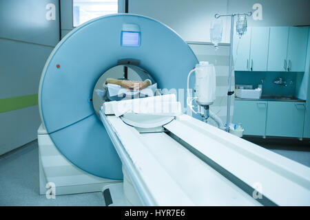 Patient being scanned and diagnosed on a CT (computed tomography) scanner in a hospital. Modern medical equipment, medicine and health care concept.