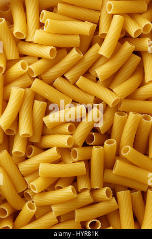 Dry uncooked rigatoni pasta background. Stock Photo