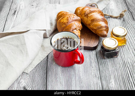 Fresh coffee cup with freshly baked croissants and jam jars.Coffee breakfast Stock Photo