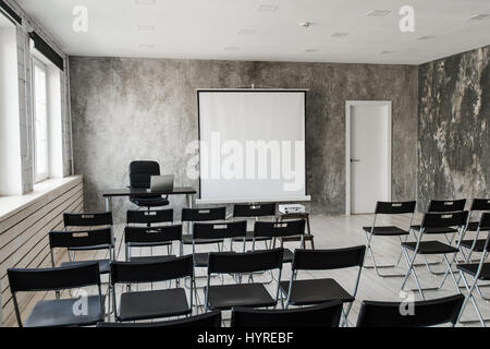 Empty modern classroom with black chairs projector screen Stock Photo