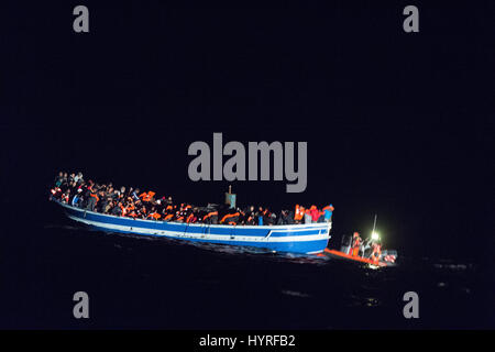 A 17 meter long wooden boat, found in the morning around 15 nautical miles away from the Libyan coast. 399 people, who are on board are trying to cros Stock Photo