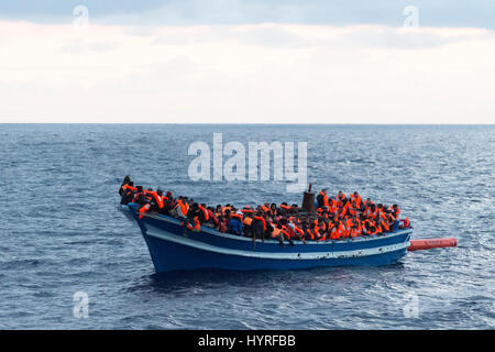 A 17 meter long wooden boat, found in the morning around 15 nautical miles away from the Libyan coast. 399 people, who are on board are trying to cros Stock Photo