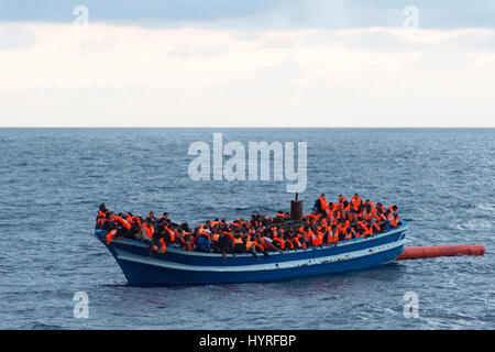 A 17 meter long wooden boat, found in the morning around 15 nautical miles away from the Libyan coast. 399 people, who are on board are trying to cros Stock Photo