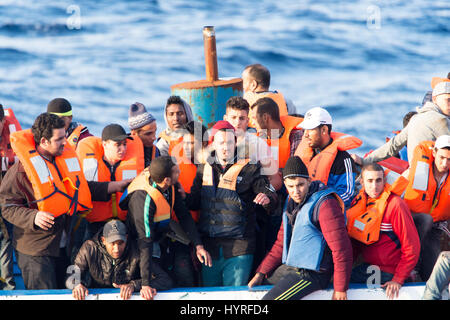 A 17 meter long wooden boat, found in the morning around 15 nautical miles away from the Libyan coast. 399 people, who are on board are trying to cros Stock Photo