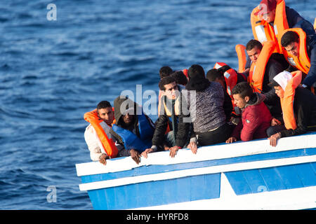 A 17 meter long wooden boat, found in the morning around 15 nautical miles away from the Libyan coast. 399 people, who are on board are trying to cros Stock Photo