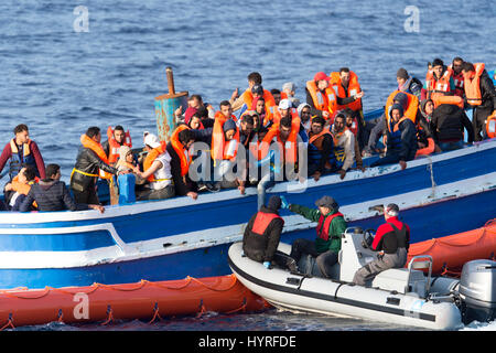 A 17 meter long wooden boat, found in the morning around 15 nautical miles away from the Libyan coast. 399 people, who are on board are trying to cros Stock Photo