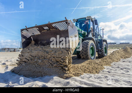 Kijkduin, the Netherlands - April 6, 2017: Tractor Front End Loader moving sand Stock Photo