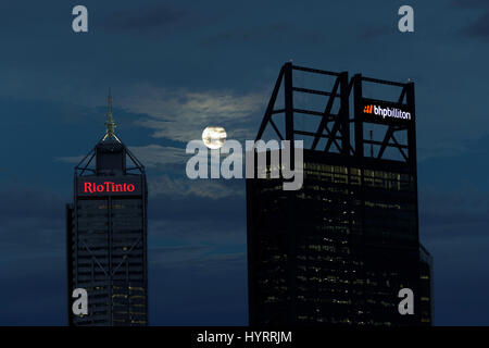 The full moon rises over the buildings occupied by mining companies BHP Blliton and Rio Tinto in Perth, Australia. Stock Photo