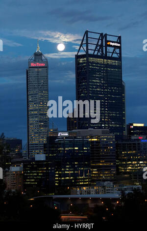 The full moon rises over the buildings occupied by mining companies BHP Blliton and Rio Tinto in Perth, Australia. Stock Photo