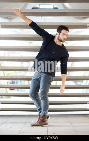 Full length portrait of a male fashion model in black clothing posing outdoors Stock Photo