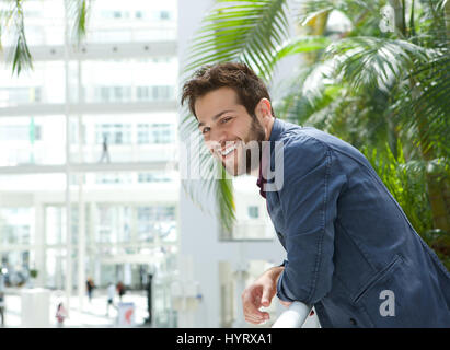 Close up portrait of a happy man leaning inside bright building Stock Photo