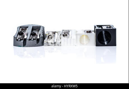 Different old used silver metallic steel plastic pencil sharpener. Multiple variety of dirty pencil sharpeners isolated on white background. Stock Photo