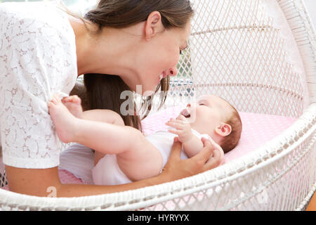 Close up portrait of a young woman smiling with newborn infant Stock Photo