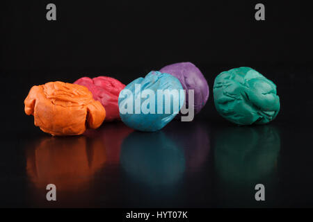 Multicoloured dirty soft clay pieces isolated on black background, art and decoration Stock Photo