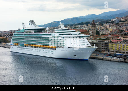 Navigator of the Seas (Royal Caribbean Cruise Lines) cruise ship docked at port and overlooking the town of Messina. Island of Sicily, Italy Stock Photo