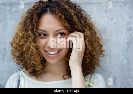 Close up portrait of a smiling young african american woman with hand in hair Stock Photo