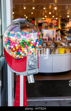 Colorful Gumball machine out in front of a candy store.
