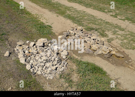 Road patching. Pits on the road are covered with stones. Stock Photo