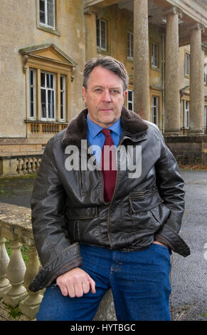 The Earl of Cardigan at his home in the Lodge (white painted) and in front of the family seat Tottenham House also showing the stable block Stock Photo