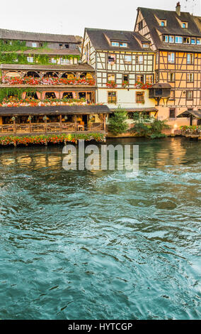 traditional half-timbered houses on the banks of river ill at dusk, Stock Photo