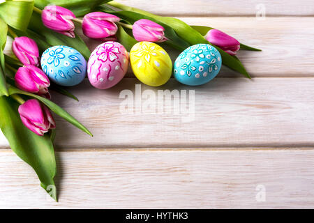 Easter background with decorated eggs  and tulips bouquet. Happy Easter greeting card or invitation. Copy space. Stock Photo