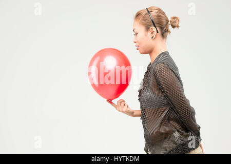 Happy beautiful asian girl play with red balloon. Action with balloon. Asian women. Conceptual. Stock Photo