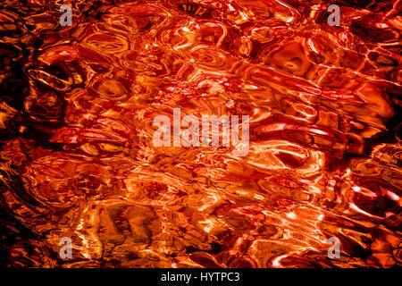 Blood red liquid water surface in sunset light. Abstract background Stock Photo
