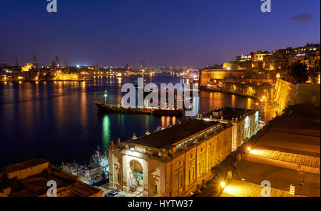 The night view of Grand Harbour with the cargo ships moored near St. Barbara Bastion from the Lower Barrakka Gardens, Valletta. Stock Photo