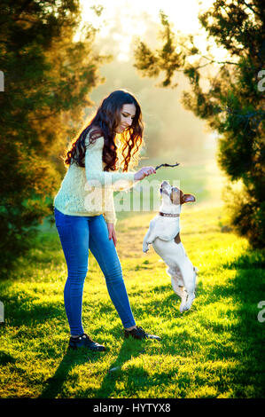 Young woman walking with a dog playing training, jumping dog. Jack Russell Terrier