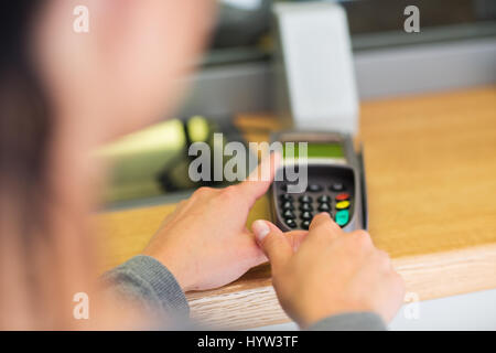 hand entering pin code to card reader terminal Stock Photo