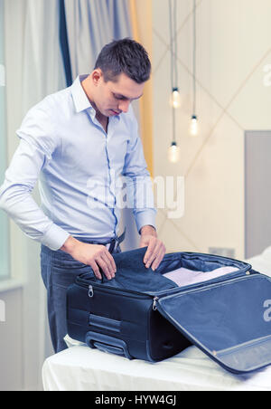 businessman packing things in suitcase Stock Photo - Alamy