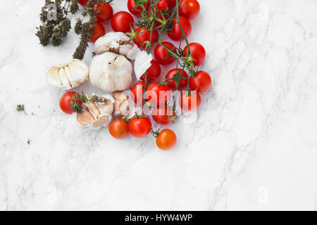 Organic cherry tomatoes with garlic and fresh thyme spice on marble stone background Stock Photo