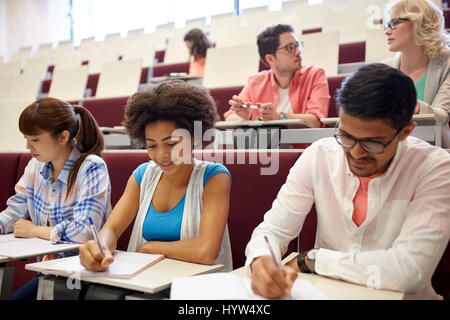 group of students with notebooks in lecture hall Stock Photo