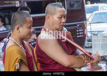 Two monks looking for alms on market, Chiang Mai, Thailnd Stock Photo