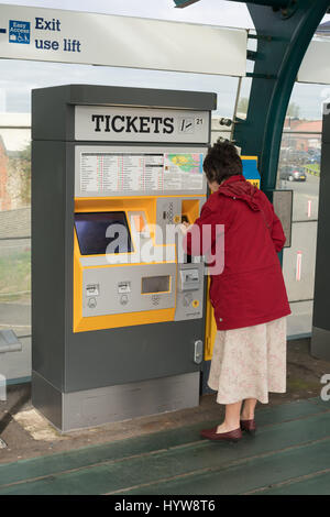 Woman buying a ticket from a vending machine on the Tyneside Metro, England, UK Stock Photo