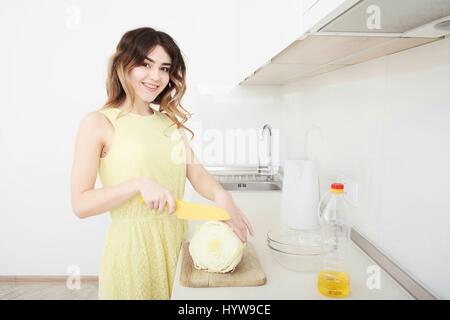 Girl cook cuts cabbage in the kitchen Stock Photo