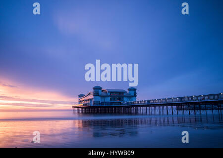 Grand Pier at Weston Super Mare reflected in wet sand and sea at sunset Stock Photo