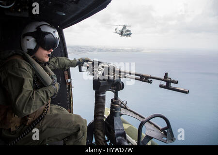Owinawa, Japan. 26th Apr, 2017. U.S. Marine Corps crew chief Cpl. Justin Fry, mans the door gun on a UH-1Y Huey helicopter, as they fly in a formation during a Mission Rehearsal Exercise April 26, 2017 in Okinawa, Japan. U.S. Forces across the Asian region have increased combat exercises as tensions continue to rise between the U.S. and North Korea. Credit: Planetpix/Alamy Live News Stock Photo