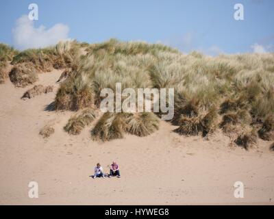 Croyde Beach, Devon, UK. 26th April 2017. Two people watch the sea on a sunny day at Croyde beach. Credit: DTNews/Alamy Live News Stock Photo