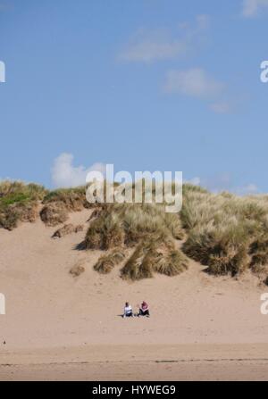 Croyde Beach, Devon, UK. 26th April 2017. Two people watch the sea on a sunny day at Croyde beach. Credit: DTNews/Alamy Live News Stock Photo