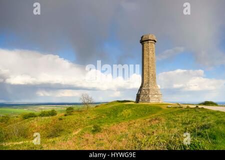 Portesham, Dorset, UK.  26th April 2017.  UK Weather.  Sunshine at Hardy Monument near Portesham in Dorset with a dark shower cloud overhead.  Hardy's Monument comemorates Vice Admiral Sir Thomas Masterman Hardy who was Flag Captain under Nelson aboard HMS Victory at the battle of Trafalgar.  Hardy lived in the nearby village of Portesham.  The monument is owned by the National Trust.  Photo Credit: Graham Hunt/Alamy Live News Stock Photo