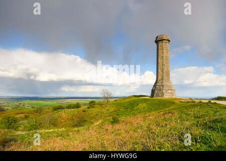 Portesham, Dorset, UK.  26th April 2017.  UK Weather.  Sunshine at Hardy Monument near Portesham in Dorset with a dark shower cloud overhead.  Hardy's Monument comemorates Vice Admiral Sir Thomas Masterman Hardy who was Flag Captain under Nelson aboard HMS Victory at the battle of Trafalgar.  Hardy lived in the nearby village of Portesham.  The monument is owned by the National Trust.  Photo Credit: Graham Hunt/Alamy Live News Stock Photo