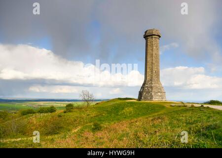 Portesham, Dorset, UK.  26th April 2017.  UK Weather.  Sunshine at Hardy Monument near Portesham in Dorset with a dark shower cloud overhead.  Hardy's Monument comemorates Vice Admiral Sir Thomas Masterman Hardy who was Flag Captain under Nelson aboard HMS Victory at the battle of Trafalgar.  Hardy lived in the nearby village of Portesham.  The monument is owned by the National Trust.  Photo Credit: Graham Hunt/Alamy Live News Stock Photo