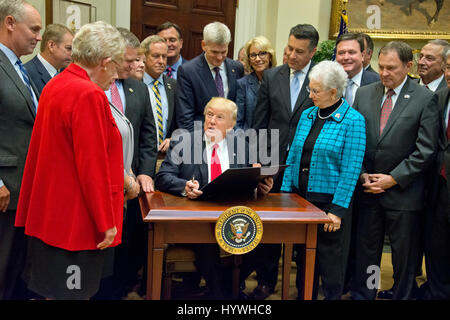 Washington DC, USA. 26th April, 2017. United States President Donald J. Trump signs the Education Federalism Executive Order as he participates in a federalism event with the nation's Governors in the Roosevelt Room of the White House in Washington, DC on Wednesday, April 26, 2017. Credit: Ron Sachs/CNP MediaPunch/Alamy Live News Stock Photo