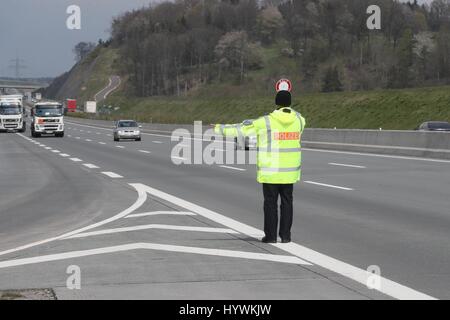 Schleiz, Germany. 26th Apr, 2017. A police officer directs traffic at a rest area of the Autobahn 9 near Schleiz, Germany, 26 April 2017. Passenger cars and trailer trucks were checked as part of a large control operation conducted by the Police, Customs, the Office for Occupational Safety and the Environmental Office. Photo: Bodo Schackow/dpa-Zentralbild/dpa/Alamy Live News