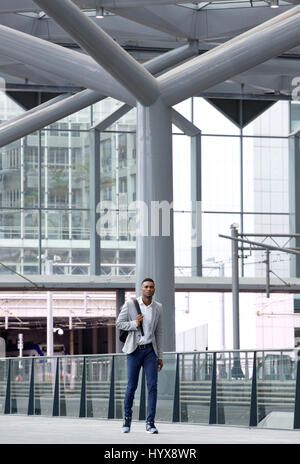 Full length portrait of an african man walking alone at airport Stock Photo