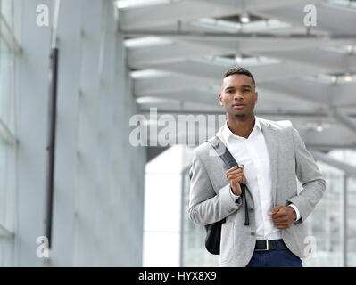 Close up portrait of an attractive young man walking with bag Stock Photo